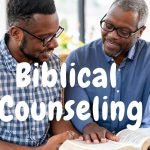 two men reading the bible together on a couch